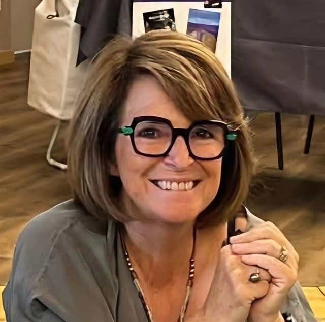 Portrait d'Annick Taquet-Assoignons, souriante, avec des lunettes